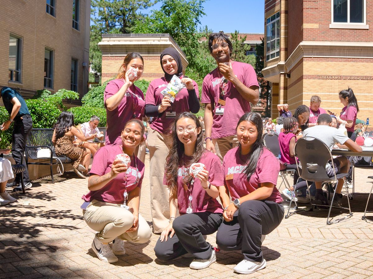MCPHS students smiling and holding snacks.
