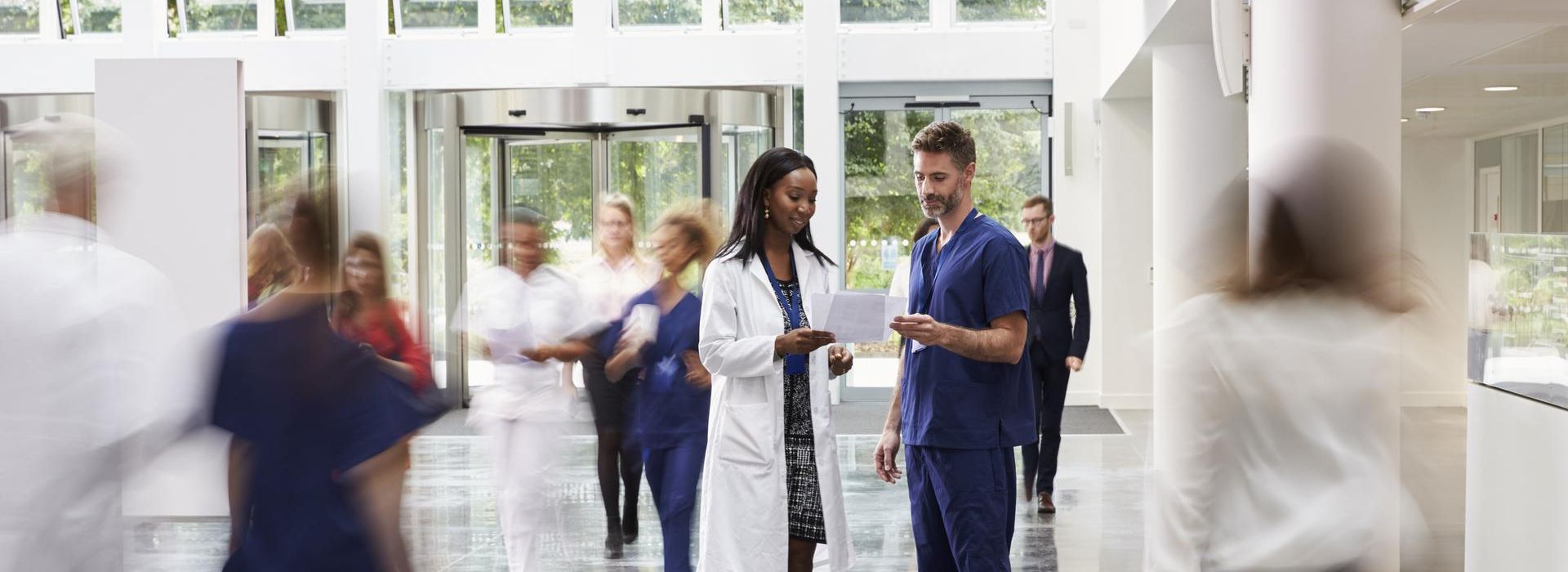 Staff In Busy Lobby Area Of Modern Hospital