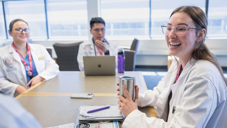 Physicians Assistant students hanging out in the library area on the Manchester campus and working in the PA lab.