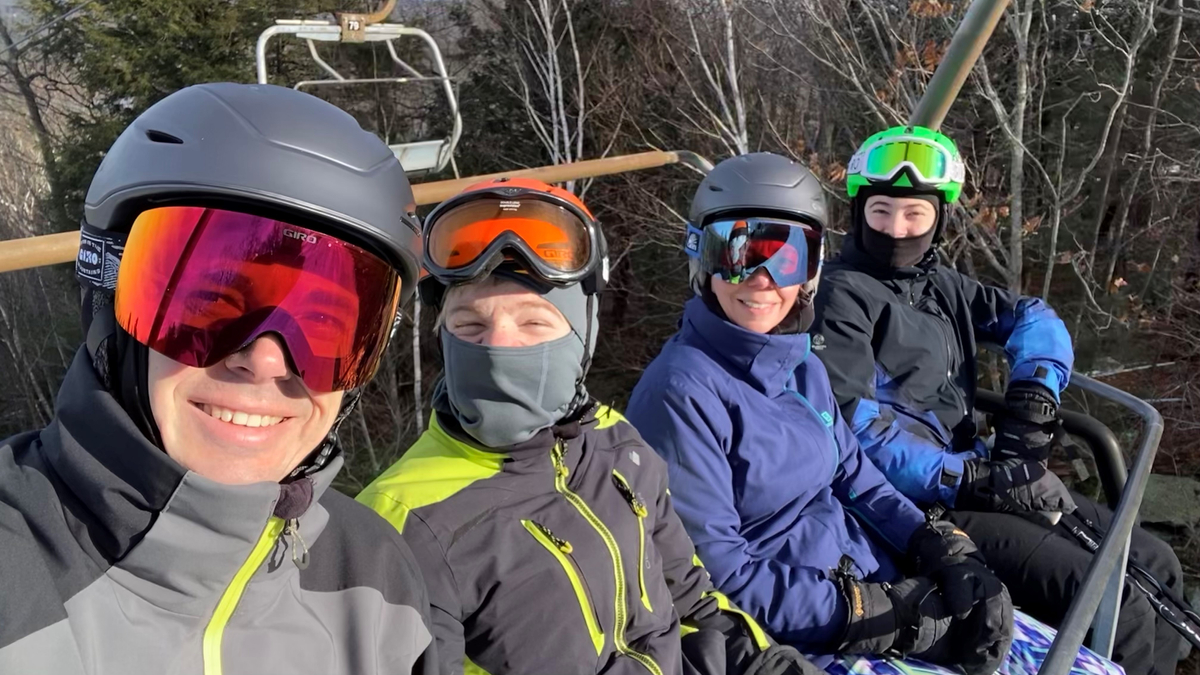 The Powers family on a ski lift wearing ski gear