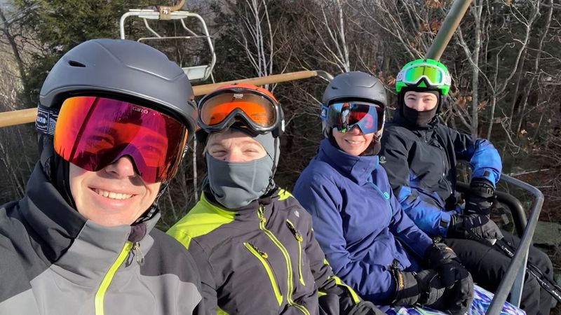 The Powers family on a ski lift wearing ski gear