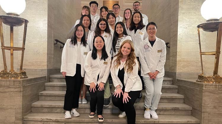 A group of MCPHS students in the APhA-ASP pose on a staircase