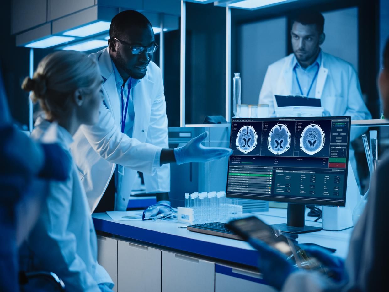 Healthcare professionals in white coats looking at an imaging scan. 