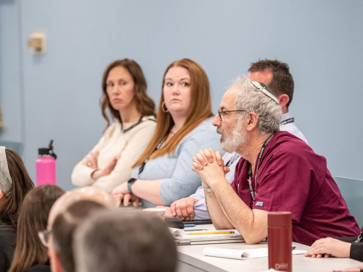 Faculty members in a classroom discussing. 