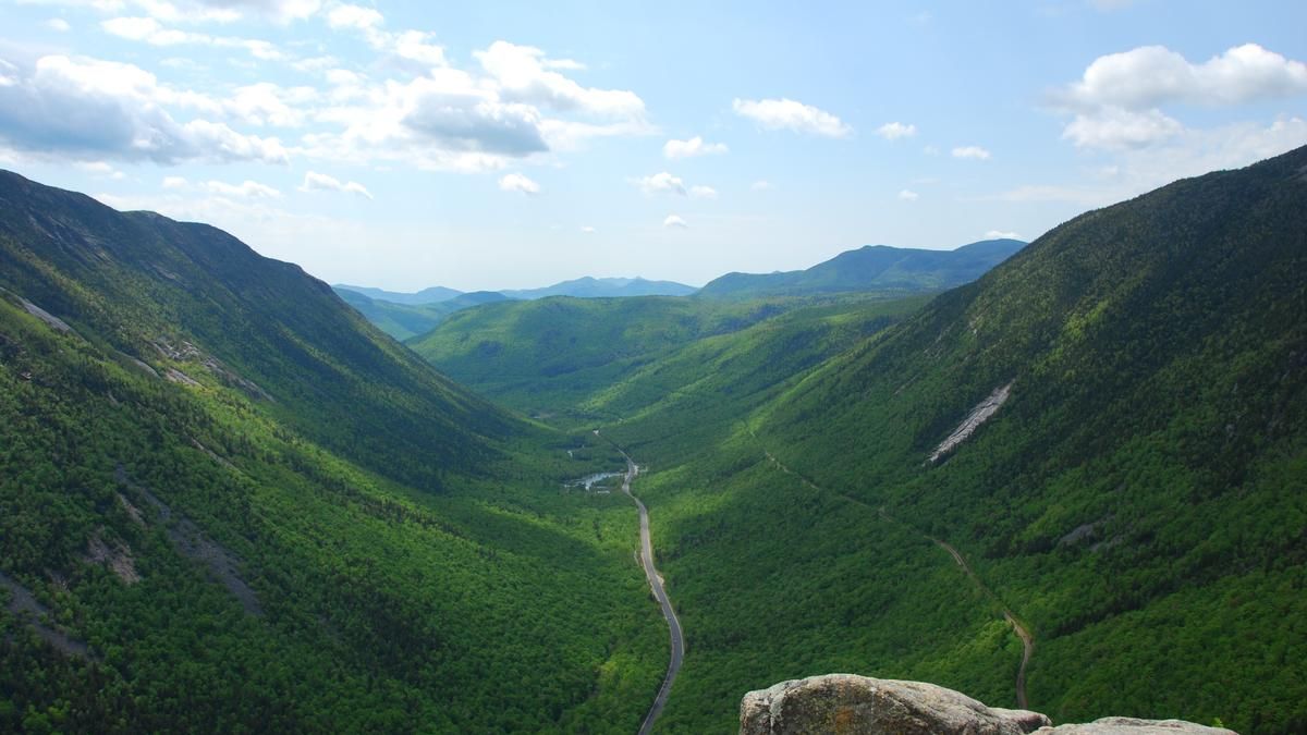A highway runs through a valley in the White Mountains of New Hampshire