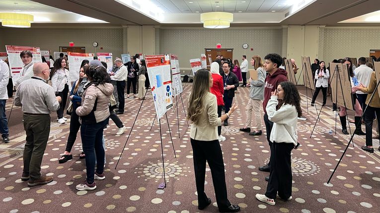 Students stand at the MCPHS Worcester/Manchester Research & Scholarship Showcase.