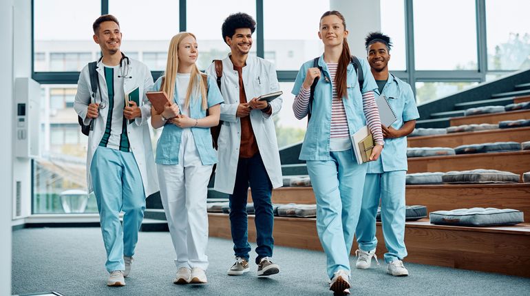 Group of medical and nursing students leaving the amphitheater after a lecture at medical university. 