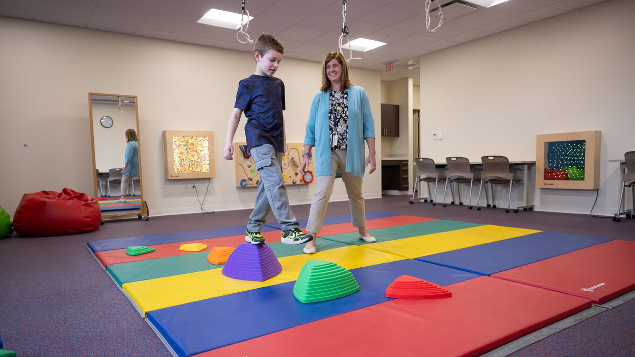Occupational Therapy in the pediatric lab on the Manchester campus. The patient is a child and is doing a various of OT exercises in the lab with the assistance from two MCPHS faculty members. 