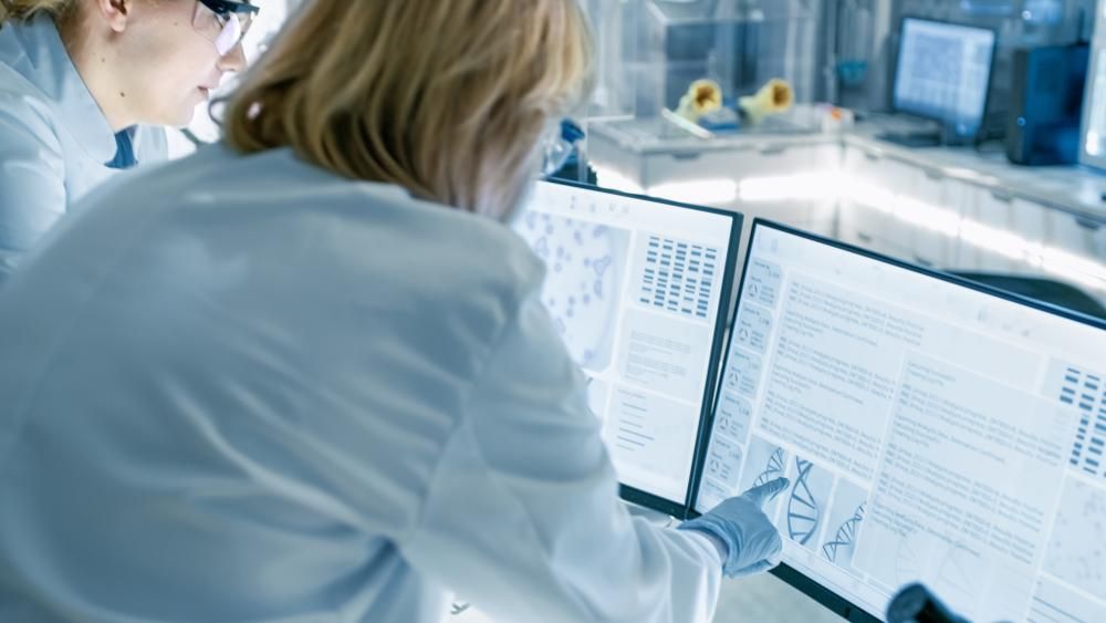 Female scientist pointing at a computer screen. 