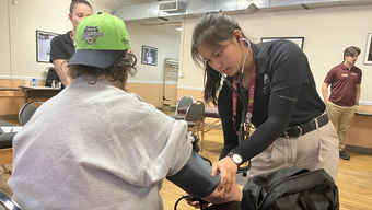 Woman takes man's blood pressure.