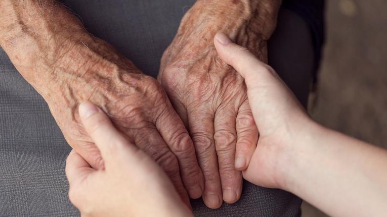 Young hands holding elderly hands