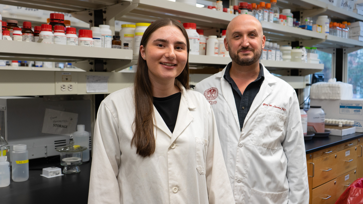 Penelope Pando and Greg Landry stand in a lab.