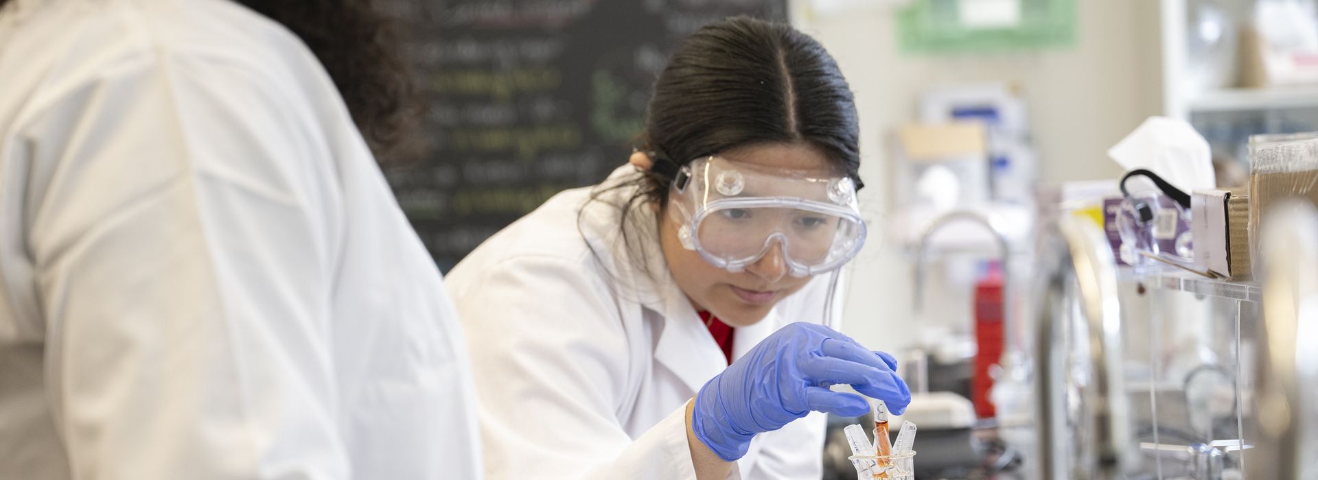 Students working in Boston lab space, professors interacting.Student's working in chemistry lab on the Boston Campus. 