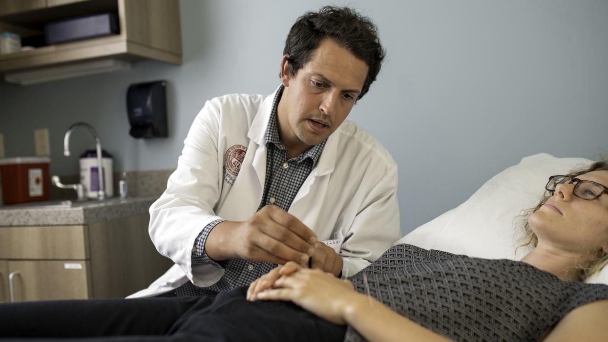  MCPHS Acupuncture student placing a needle in a patients hand. 