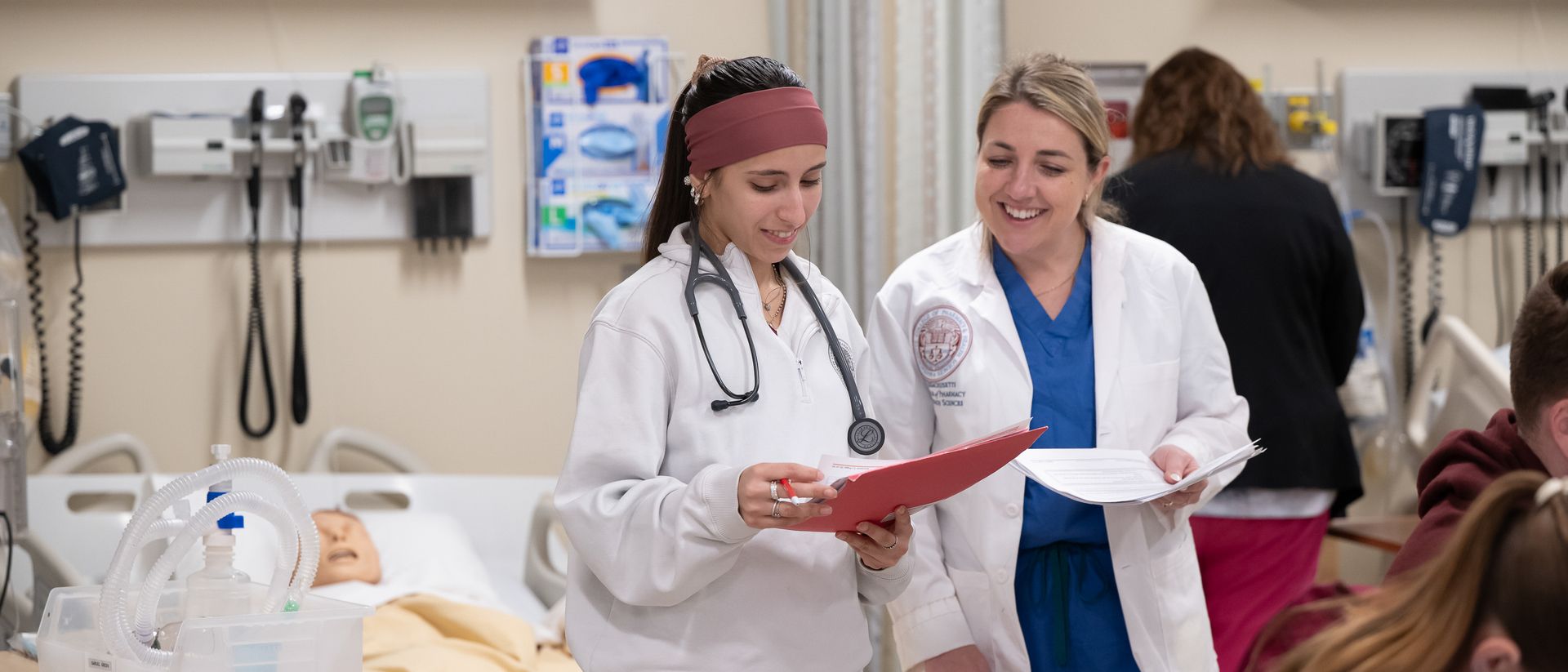 Nursing students working in group lab on the Boston campus, practicing on manikins.