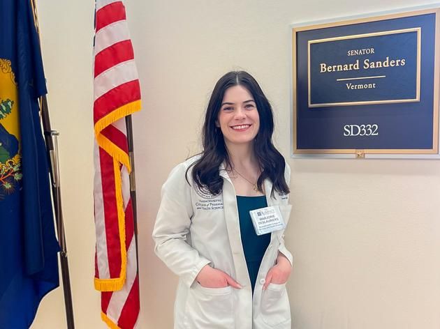 A pharmacy student wearing a white coat.