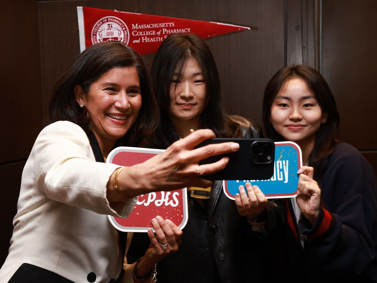 Three women smiling and taking a selfie. 
