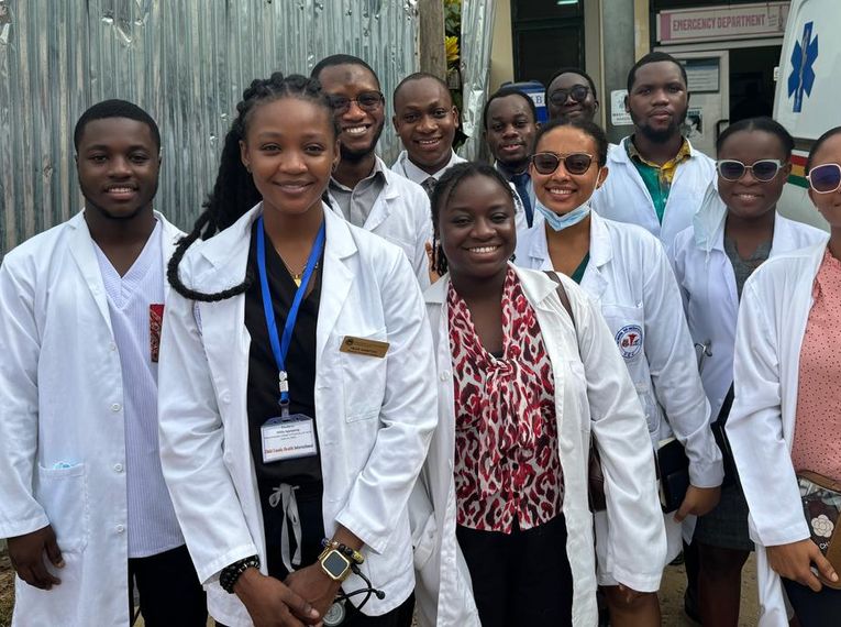 Students standing in front of an ambulance in Ghana.