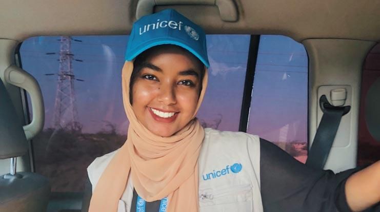 Smiling female wearing a UNICEF cap. 