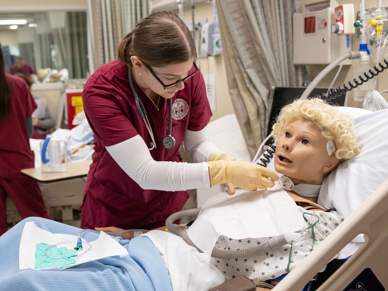 Nursing students working in group lab on the Boston campus, practicing on manikins.