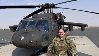 Captain Amanda Woods stands in front of helicopter.