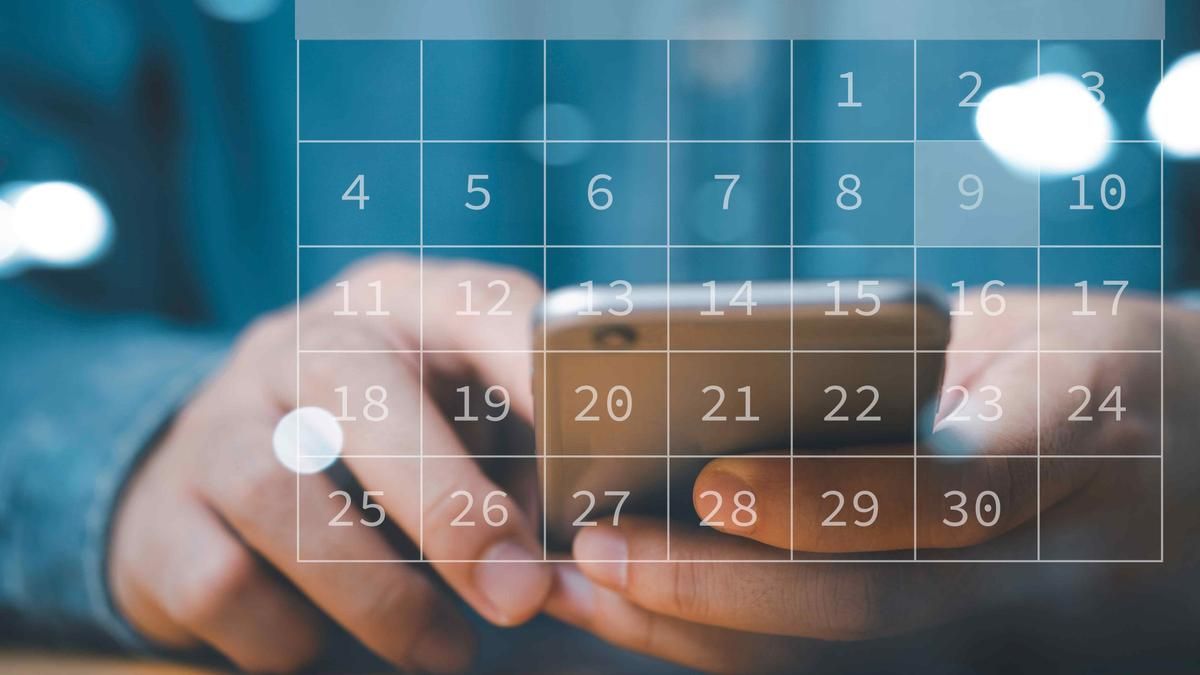 Close-up of hands using a mobile phone with a calendar image. 
