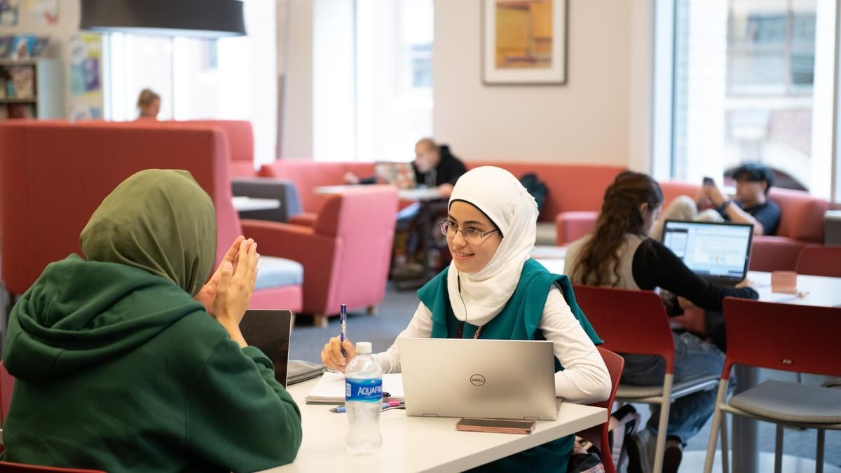two female students on laptops studying