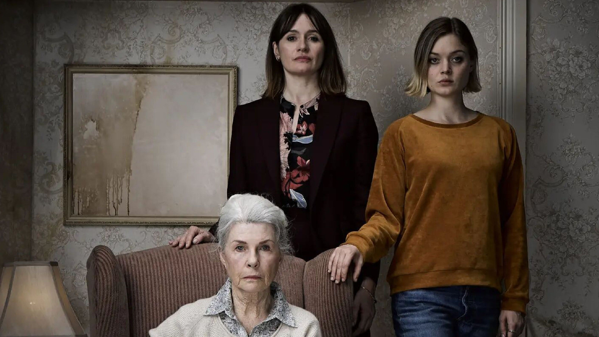 Three women in front of a mirror.