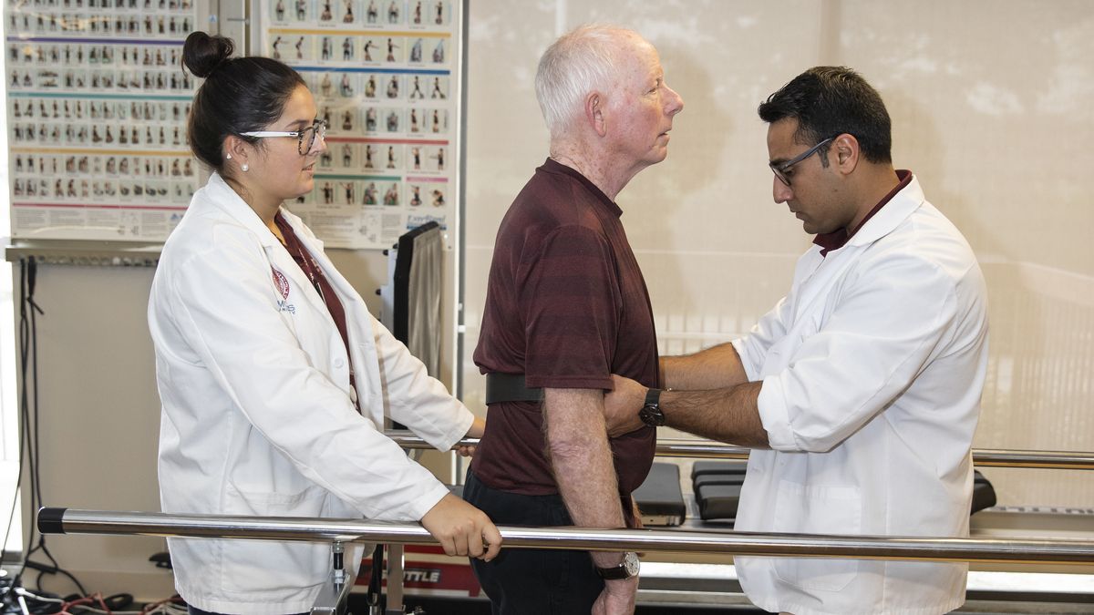 Male and female PT students working with a patient.