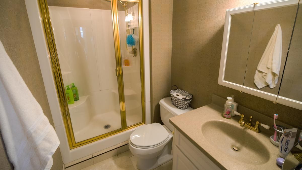 An example of a bathroom with glass shower, toilet and sink. 