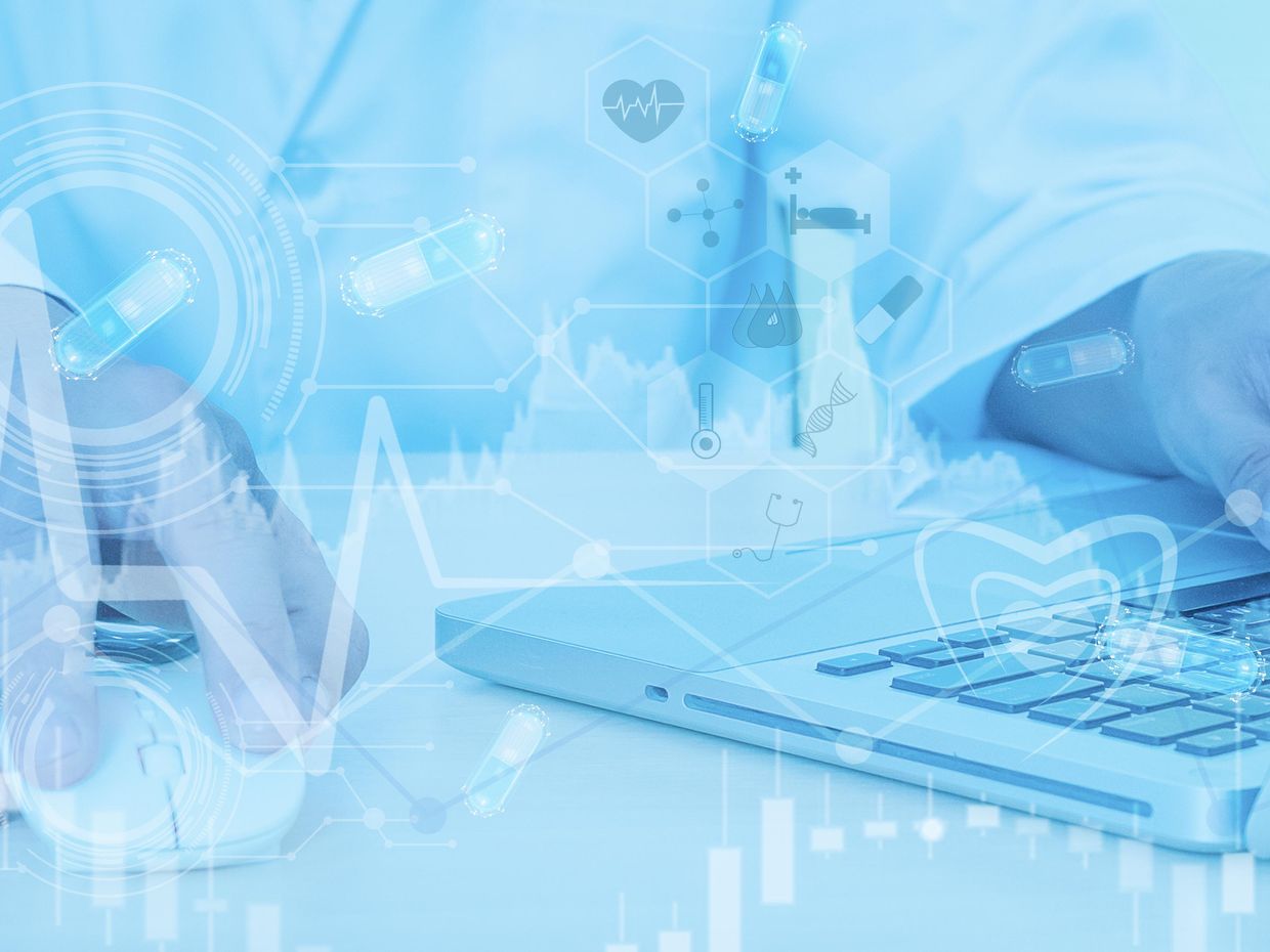 Close up of hand on laptop and medical icons. 