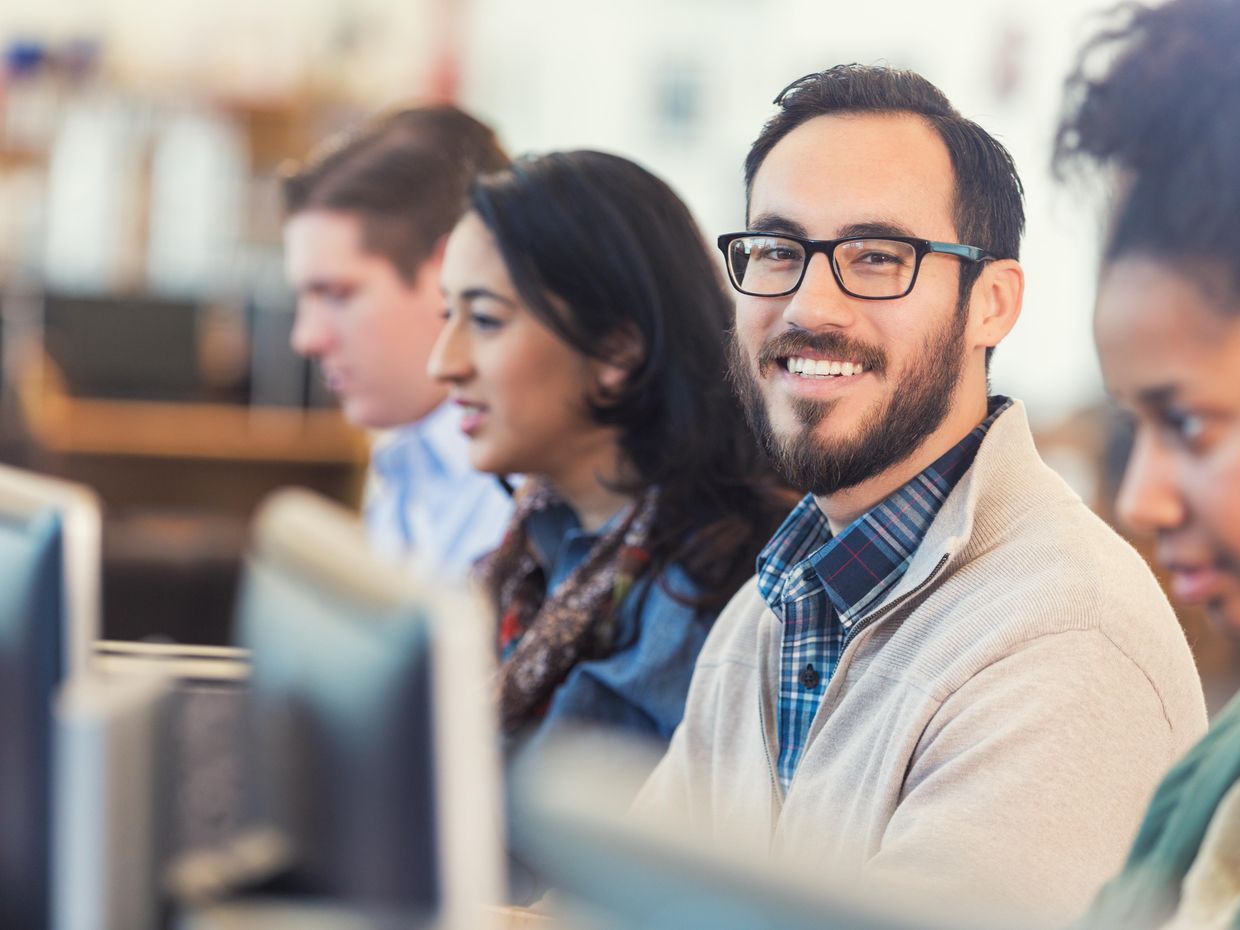 Smiling male in a classroom. 