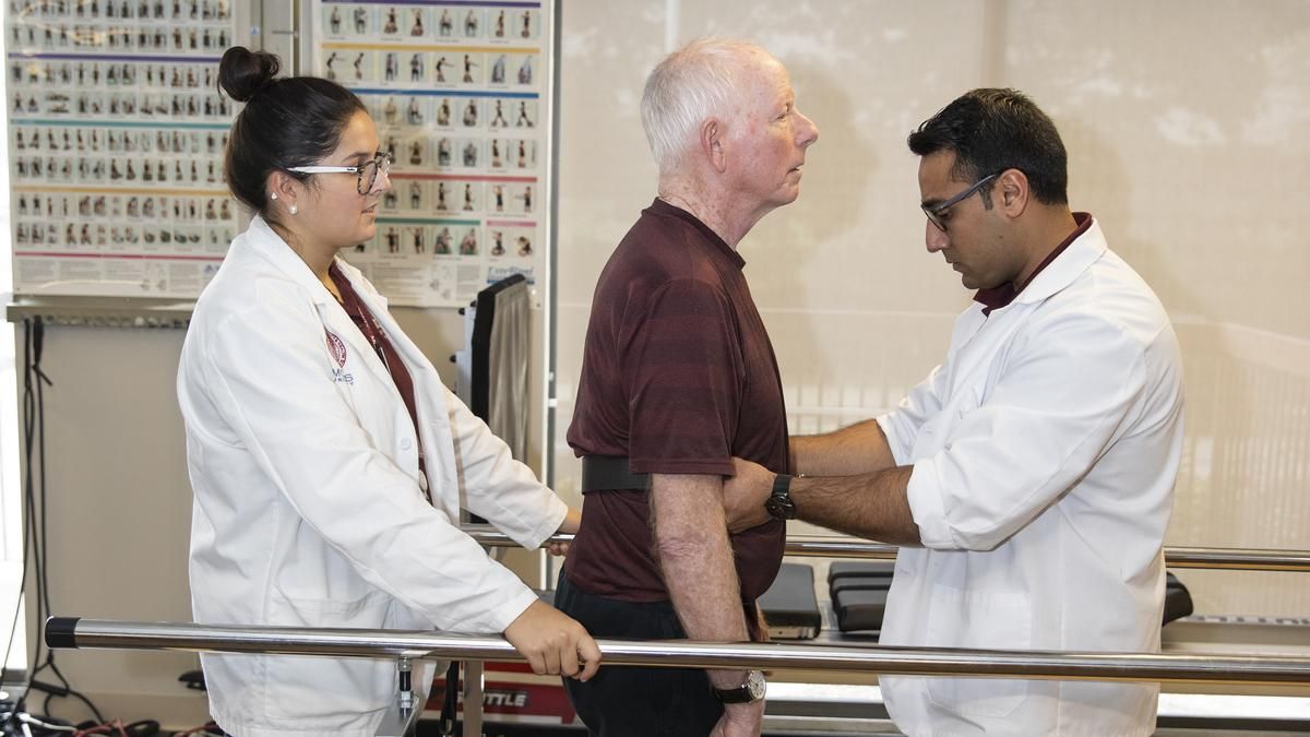 Male and female Physical Therapy students working with a patient at the MCPHS Balance, Movement and Wellness Center. 