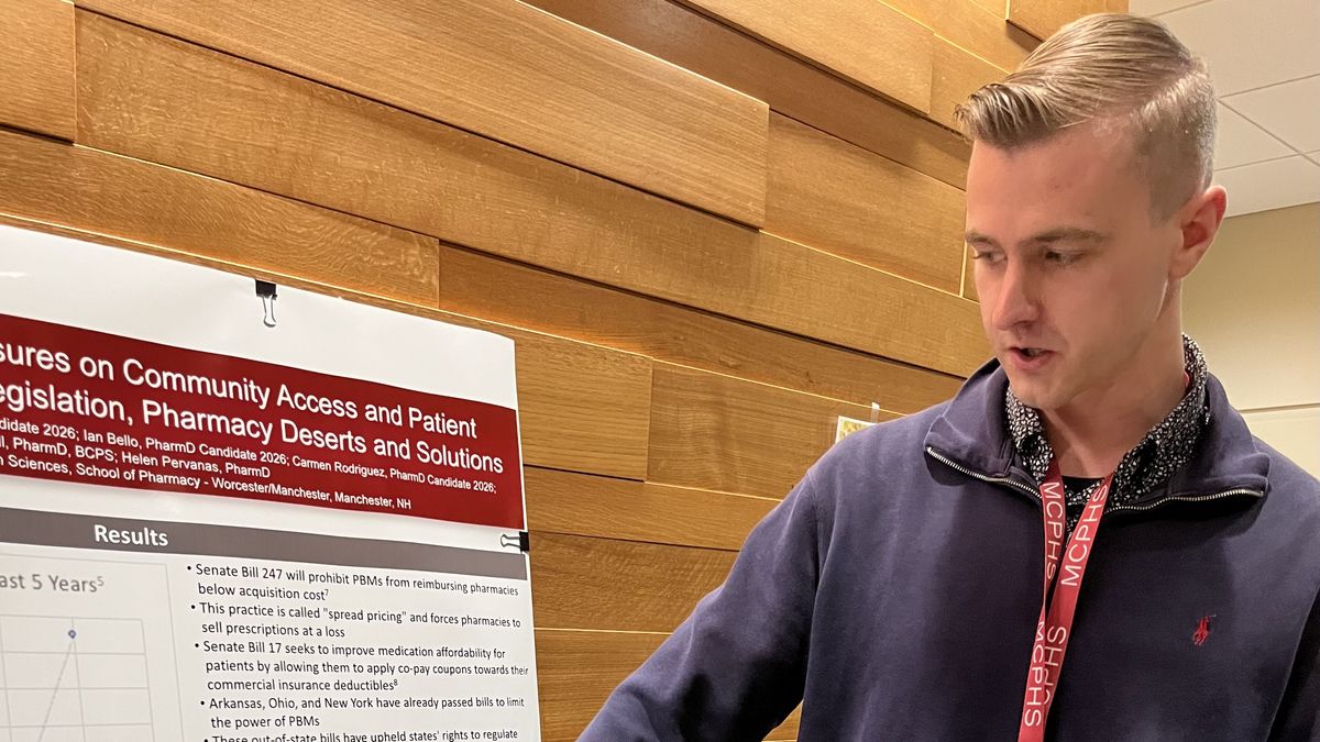 A man points to a poster.