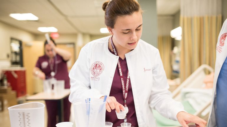 MCPHS Nursing Student in white coat. 