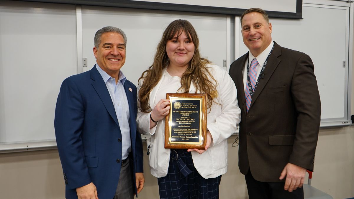 Kaylee Eacho holds an award at the MCPHS Boston Capstone Business Plan Competition.