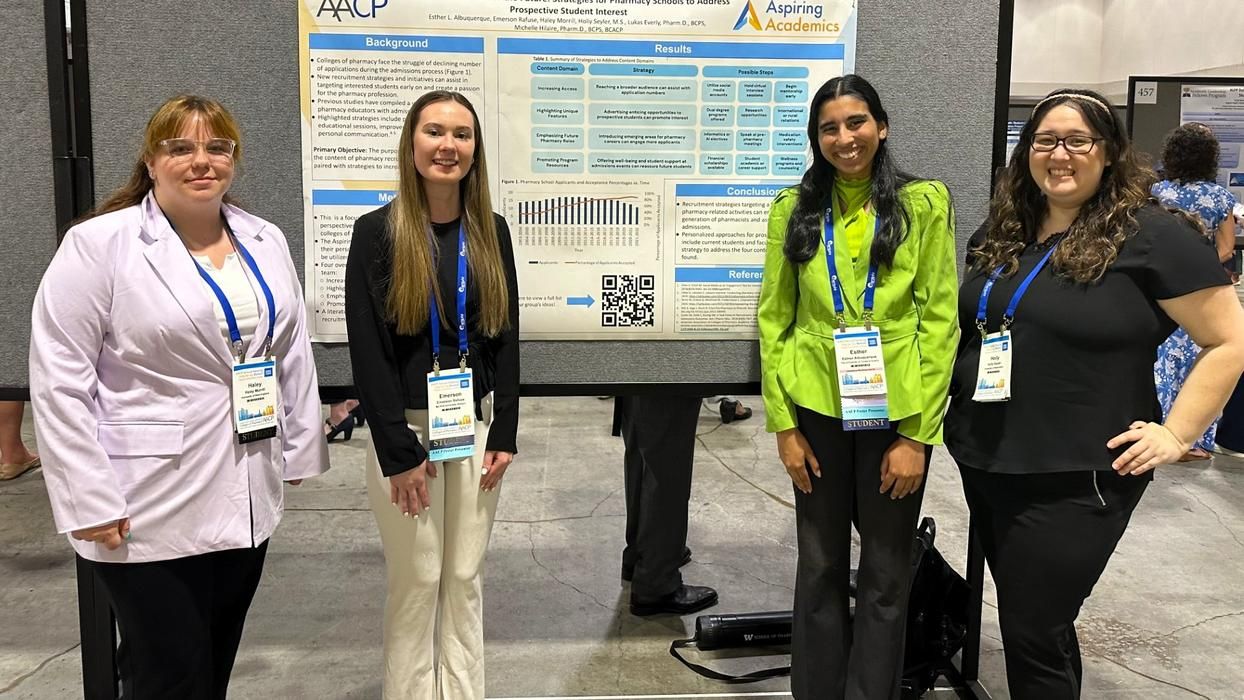 Students at Aspiring Academics program stand in front of poster.