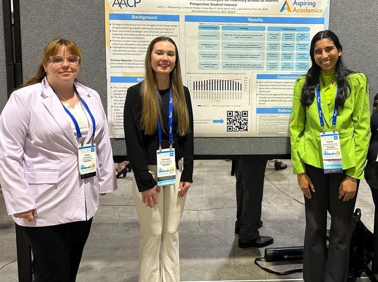 Students at Aspiring Academics program stand in front of poster.