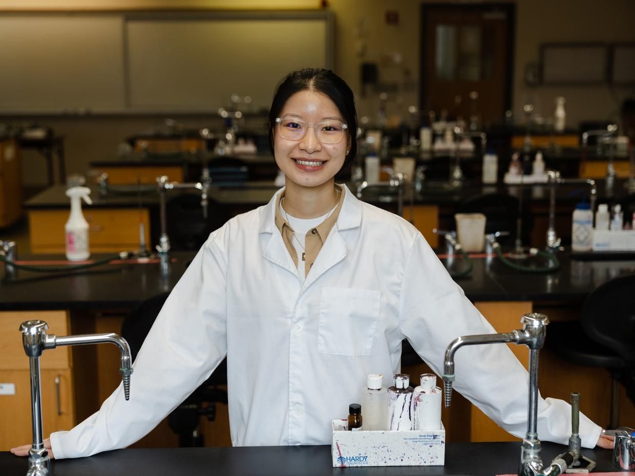 Smiling female student in a lab. 
