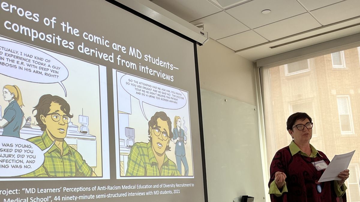 Ellen Amster stands in front of a screen.