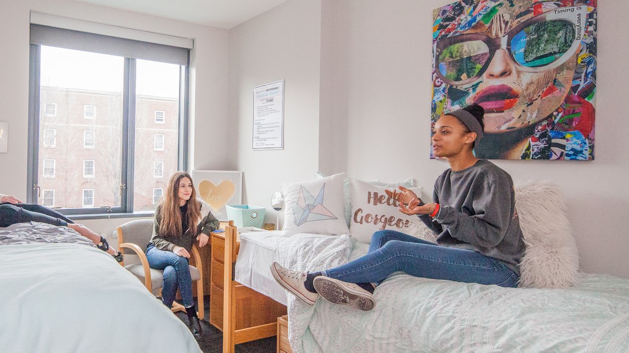 two female students sitting in a dorm room. 