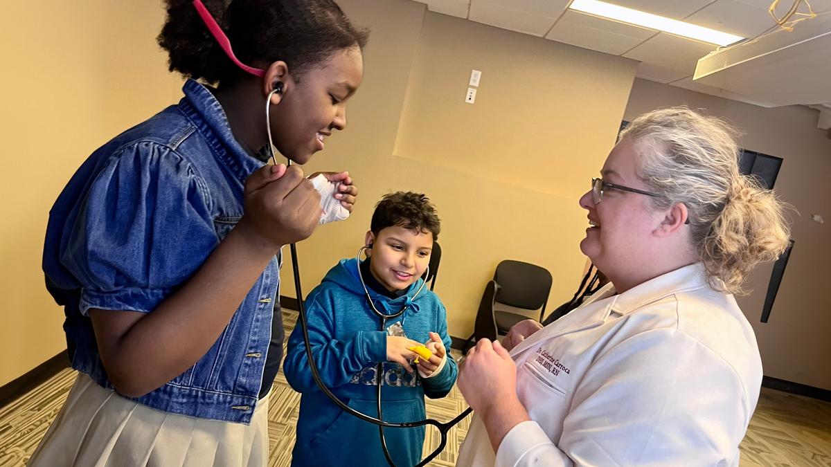 A girl and boy use stethoscopes.