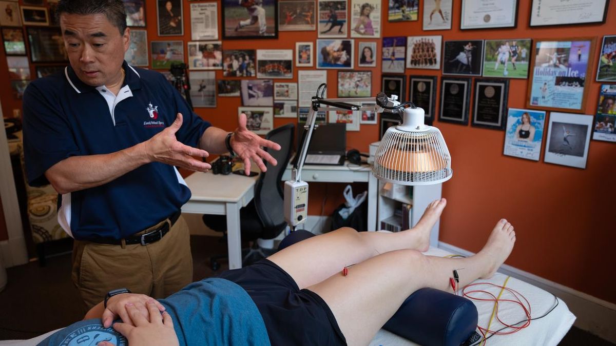 George Leung demonstrates electroacupuncture on a patient.