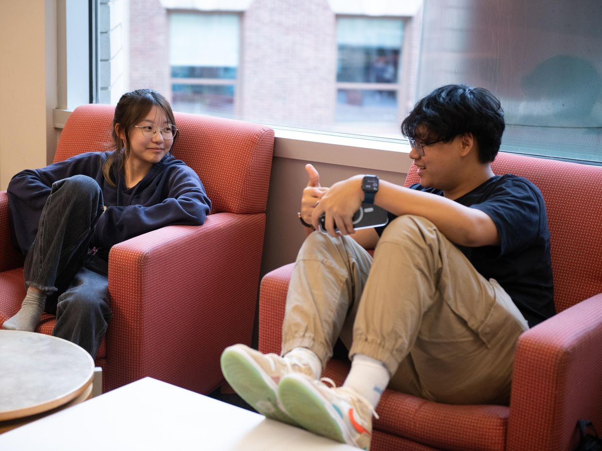 Female and male student talking in the library. 