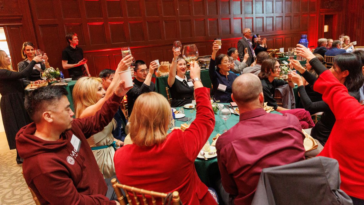 People raising drinks to toast.