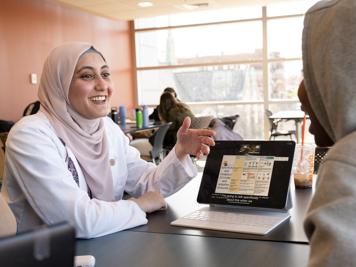 Smiling student with laptop open. 