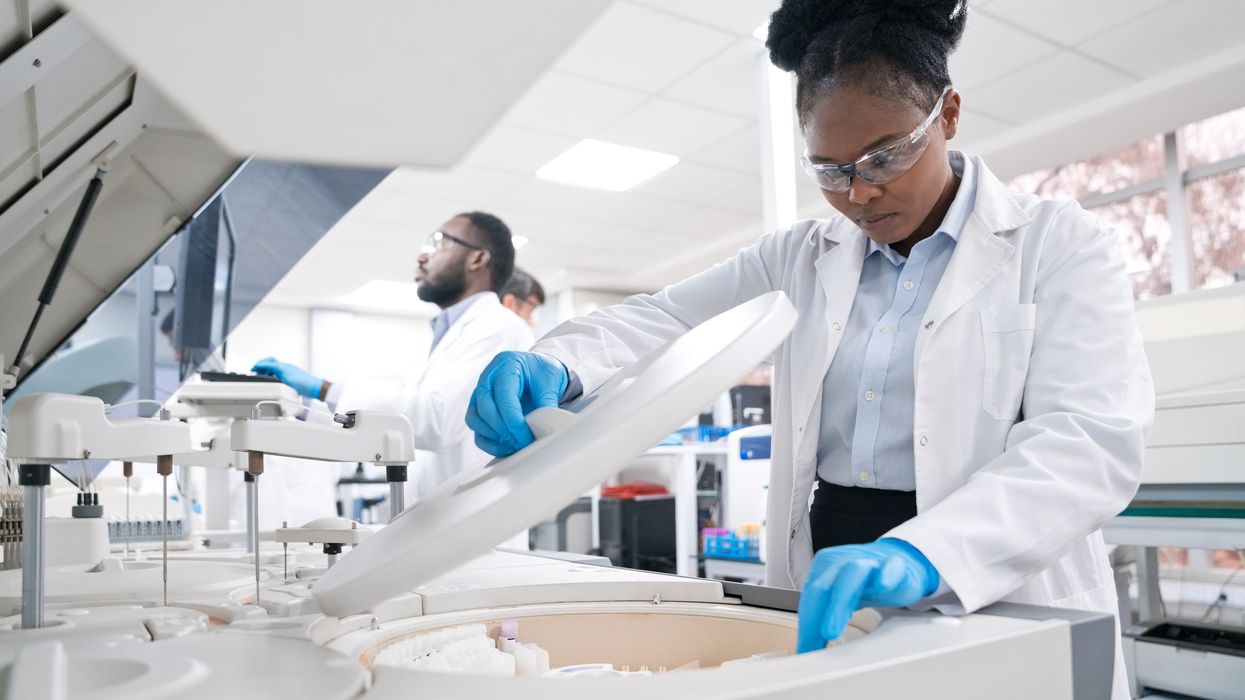 Female medical worker wearing lab coat while working in laboratory.