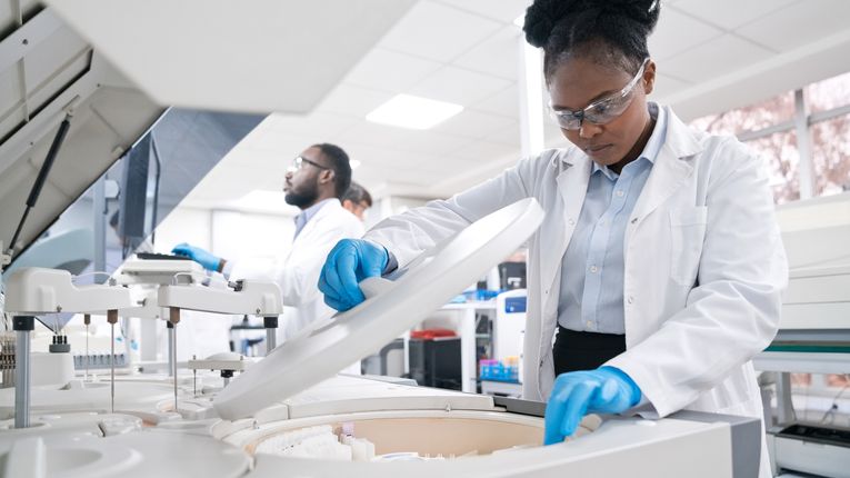 Female medical worker wearing lab coat while working in laboratory.