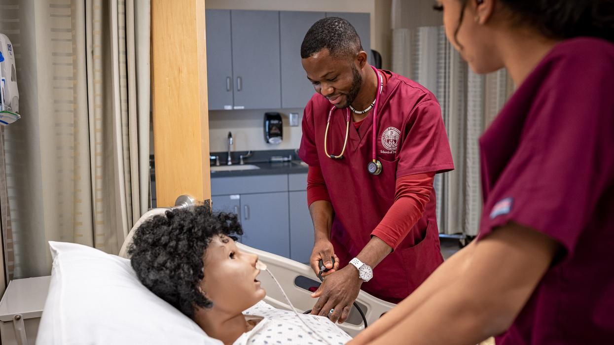 MCPHS male nursing student working on a manikin. 