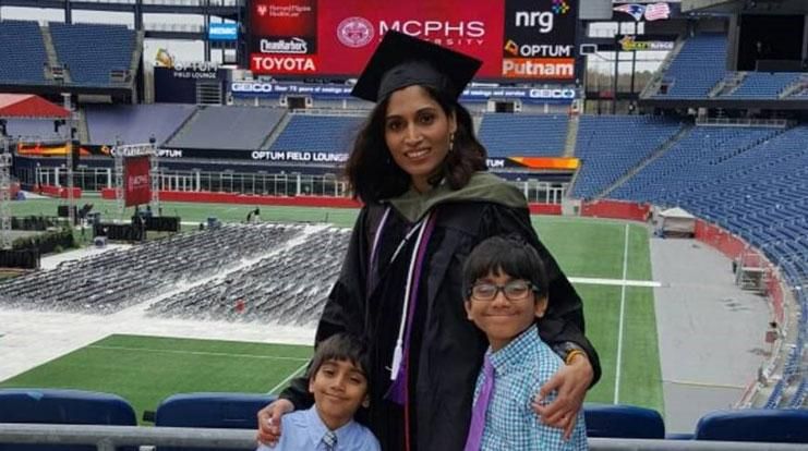 Bisni Narayanan, PharmD '15, MS, poses with her two young children at Gillette Stadium after graduating from MCPHS